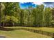 Picturesque backyard with a well-maintained lawn enclosed by a wooden fence and lush trees at 145 Carrington Ln, Brooks, GA 30205
