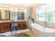 This bathroom features double sinks, a soaking tub, and a view to the outdoors at 145 Carrington Ln, Brooks, GA 30205