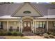 Charming front entrance with stone pathway, rocking chairs, and a decorative wood door at 145 Carrington Ln, Brooks, GA 30205
