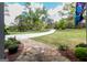 Well-manicured front yard with a curved driveway, lush greenery, and mature trees at 145 Carrington Ln, Brooks, GA 30205