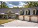 Close-up of a home's facade with a stone-accented three-car garage and well-manicured landscaping at 145 Carrington Ln, Brooks, GA 30205