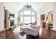 Living room features cathedral ceiling, fireplace, hardwood floors, and large windows at 145 Carrington Ln, Brooks, GA 30205