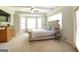 Spacious main bedroom featuring a tray ceiling, bay windows, and plush carpeting at 145 Carrington Ln, Brooks, GA 30205
