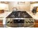 Close-up of stainless steel range with a pot filler, tile backsplash, and granite countertops at 145 Carrington Ln, Brooks, GA 30205