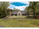 Expansive rear exterior of a home featuring a fenced-in yard, covered patios, and beautiful landscaping at 145 Carrington Ln, Brooks, GA 30205