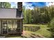 Cozy screened porch with stone fireplace overlooks a fenced backyard and wooded area at 145 Carrington Ln, Brooks, GA 30205