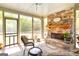 Inviting sunroom with stone fireplace, screened windows, and views of the landscaped backyard and pastures at 145 Carrington Ln, Brooks, GA 30205