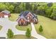Aerial view of the brick home, detached garage, and winding driveway in a lush green yard at 2351 Rabbit Farm Cir, Loganville, GA 30052