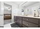 Bathroom features vanity with dark cabinets, mirror, and access to bedroom at 2351 Rabbit Farm Cir, Loganville, GA 30052