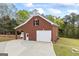 Large brick detached garage with ample parking space, featuring a covered area and well-maintained surroundings at 2351 Rabbit Farm Cir, Loganville, GA 30052