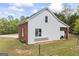 Garage with partial brick facade and neutral siding, along with a well-kept yard and surrounding greenery at 2351 Rabbit Farm Cir, Loganville, GA 30052