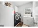 Laundry room features modern washer and dryer and a utility sink with storage at 2351 Rabbit Farm Cir, Loganville, GA 30052