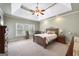 Relaxing main bedroom featuring tray ceilings, recessed lighting, fan and comfortable furnishings at 2351 Rabbit Farm Cir, Loganville, GA 30052