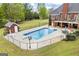 Large backyard with a diving pool, a pool house and a surrounding fenced yard with mature trees and landscaping at 2351 Rabbit Farm Cir, Loganville, GA 30052
