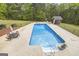 Aerial view of a large in-ground pool surrounded by a concrete patio, lush greenery and pool house at 2351 Rabbit Farm Cir, Loganville, GA 30052