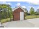 A brick pool shed with a white door and a concrete pad in a fenced yard at 2351 Rabbit Farm Cir, Loganville, GA 30052