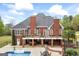 Back exterior of brick home with upper deck overlooking the pool and outdoor dining, entertaining area below at 2351 Rabbit Farm Cir, Loganville, GA 30052