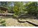 Beautiful backyard oasis with stone features, lush greenery, and a charming covered deck at 180 Paces Dr, Fayetteville, GA 30215