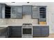 Kitchen featuring stainless steel range, blue cabinets, quartz countertops and stainless steel sink at 180 Paces Dr, Fayetteville, GA 30215
