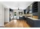Stylish kitchen boasts stainless steel appliances, dark cabinetry, and hardwood floors at 180 Paces Dr, Fayetteville, GA 30215