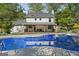Back of house with a covered porch overlooking a spacious pool and backyard at 180 Paces Dr, Fayetteville, GA 30215