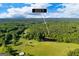 Expansive aerial view of the 4383 Pool Road property featuring a tranquil pond and lush surrounding greenery at 4383 Pool Rd, Winston, GA 30187