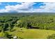 Scenic aerial of the property featuring a pond, pasture, and surrounding trees at 4383 Pool Rd, Winston, GA 30187