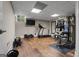 Basement gym with hardwood floors, a mounted TV, a full mirror, and a weight machine at 4383 Pool Rd, Winston, GA 30187