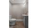 Powder room featuring wood-style floors, a grey vanity, and a water closet at 4383 Pool Rd, Winston, GA 30187