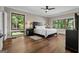 Inviting bedroom with hardwood floors, large windows offering natural light, and a comfortable bed with stylish lamps at 4383 Pool Rd, Winston, GA 30187