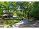 Long driveway leads to a home with a three-car garage next to a lake in the trees at 4383 Pool Rd, Winston, GA 30187