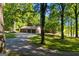 Long, winding driveway leading to a home with a three-car garage surrounded by verdant trees and a tranquil lake at 4383 Pool Rd, Winston, GA 30187