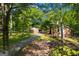 Exterior view of the brick home featuring a long driveway, mature trees, and a well-maintained lawn at 4383 Pool Rd, Winston, GA 30187