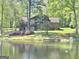 A brick home with a scenic view of a lake and lush green trees at 4383 Pool Rd, Winston, GA 30187