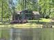 Beautiful exterior view of the brick home overlooking a scenic lake and lush greenery at 4383 Pool Rd, Winston, GA 30187