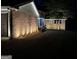Nighttime view of home with brick accents, well-lit driveway, and manicured landscaping at 4383 Pool Rd, Winston, GA 30187