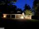 Well-lit home exterior at night features a brick facade and multi-car garage at 4383 Pool Rd, Winston, GA 30187