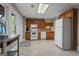 A traditional-style kitchen with white appliances, wood cabinetry and a textured tile floor at 4383 Pool Rd, Winston, GA 30187