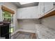 Well-organized laundry room with granite countertops, ample storage, and a window overlooking the yard at 4383 Pool Rd, Winston, GA 30187