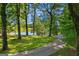 Scenic view of the pond and gazebo framed by mature shade trees along the driveway at 4383 Pool Rd, Winston, GA 30187