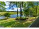 Scenic view of a serene pond with a dock and lush green fields, surrounded by trees at 4383 Pool Rd, Winston, GA 30187