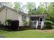 View of the backyard with a green lawn, landscaping, and access to a screened-in porch at 206 Pine Cedar Cir, Brooks, GA 30205