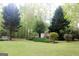 View of the backyard with a green lawn, landscaping, and house in the background at 206 Pine Cedar Cir, Brooks, GA 30205