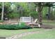 View of the backyard with a stone pathway, green grass, and garden area at 206 Pine Cedar Cir, Brooks, GA 30205