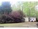 View of the backyard with a small yellow shed and lawn mower at 206 Pine Cedar Cir, Brooks, GA 30205