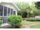View of the backyard with a green lawn, stone pathway, and screened-in porch at 206 Pine Cedar Cir, Brooks, GA 30205