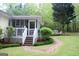 View of the backyard with a green lawn, stone pathway, and screened-in porch at 206 Pine Cedar Cir, Brooks, GA 30205