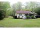 View of the backyard with green grass and access to a screened-in porch at 206 Pine Cedar Cir, Brooks, GA 30205