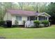 View of the backyard with a green lawn, landscaping, and access to a screened-in porch at 206 Pine Cedar Cir, Brooks, GA 30205