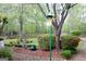 Landscaped backyard with a decorative yard bell, flowering shrubs, and a charming stone pathway at 206 Pine Cedar Cir, Brooks, GA 30205
